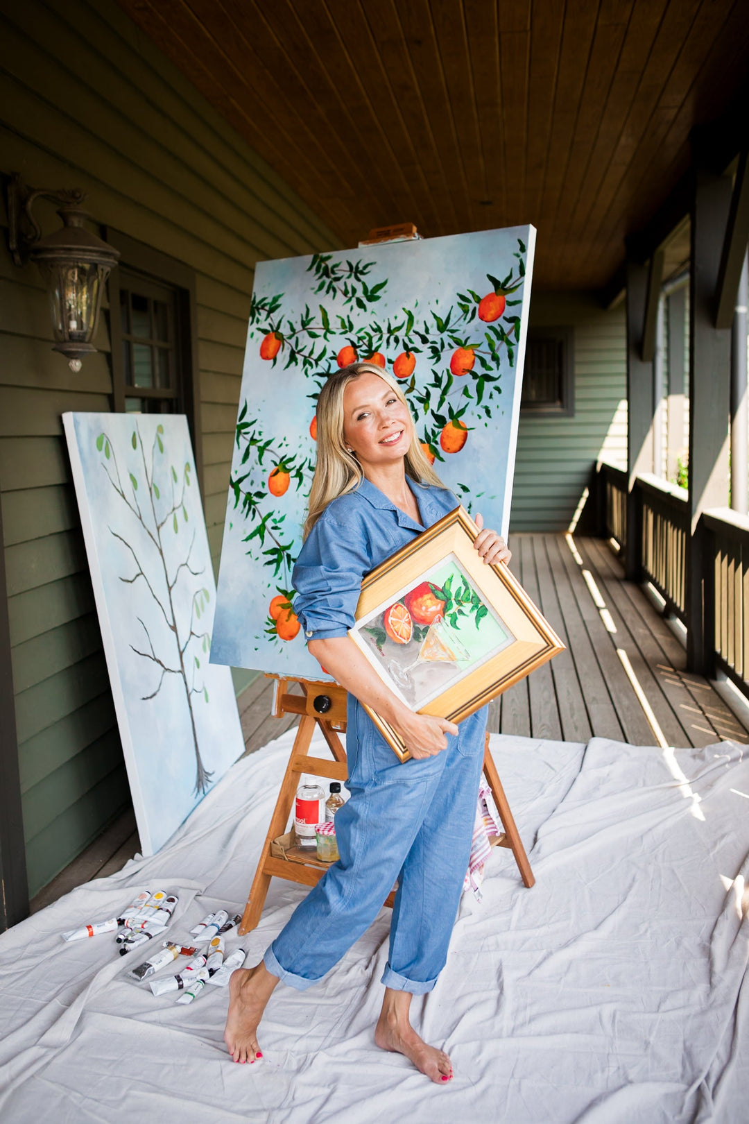 rtist Arden Upton posing with original citrus artwork and framed painting, featured in House & Garden UK. Contemporary Southern fine art inspired by gardens, nature, and timeless interiors.