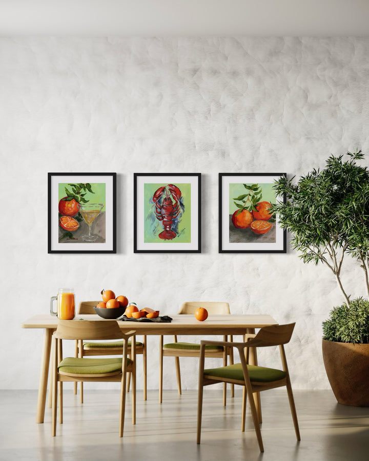 Best gallery wall ideas for dining rooms – 3 paintings of a bold lobster, oranges and a martini and more oranges foodie art prints, framed for easy hang and timeless Southern style. Hung in dining area as a curated set over table with oranges and orange juice