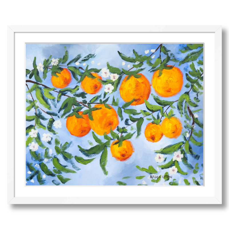 A ready to hang, framed giclee art print featuring a painting of oranges on a tree with white flowers and a blue sky background by Arden Upton from her Orangerie Collection. Art for Gallery walls, kitchens, bright and happy spaces