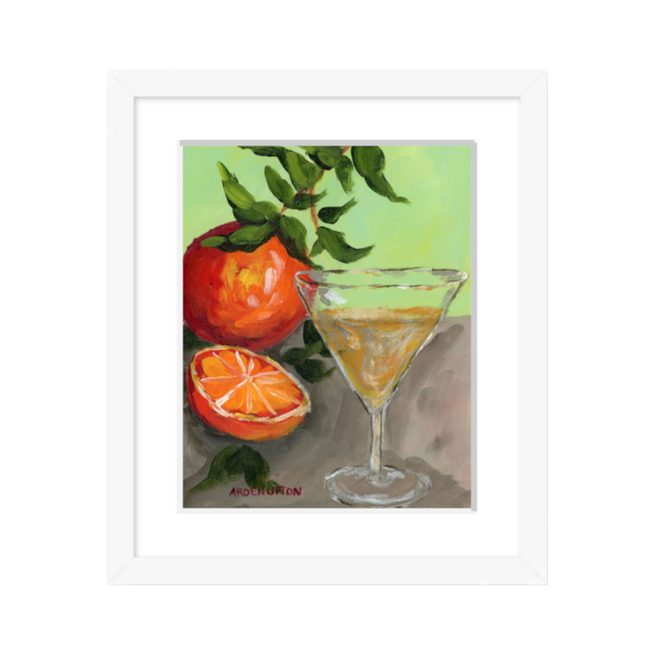 Food-inspired painting of beautiful Oranges and a Martini  in bold oranges and red with an orange tree stem on a grey table with a lime green background, framed in a white frame great  for kitchens and dining room gallery walls