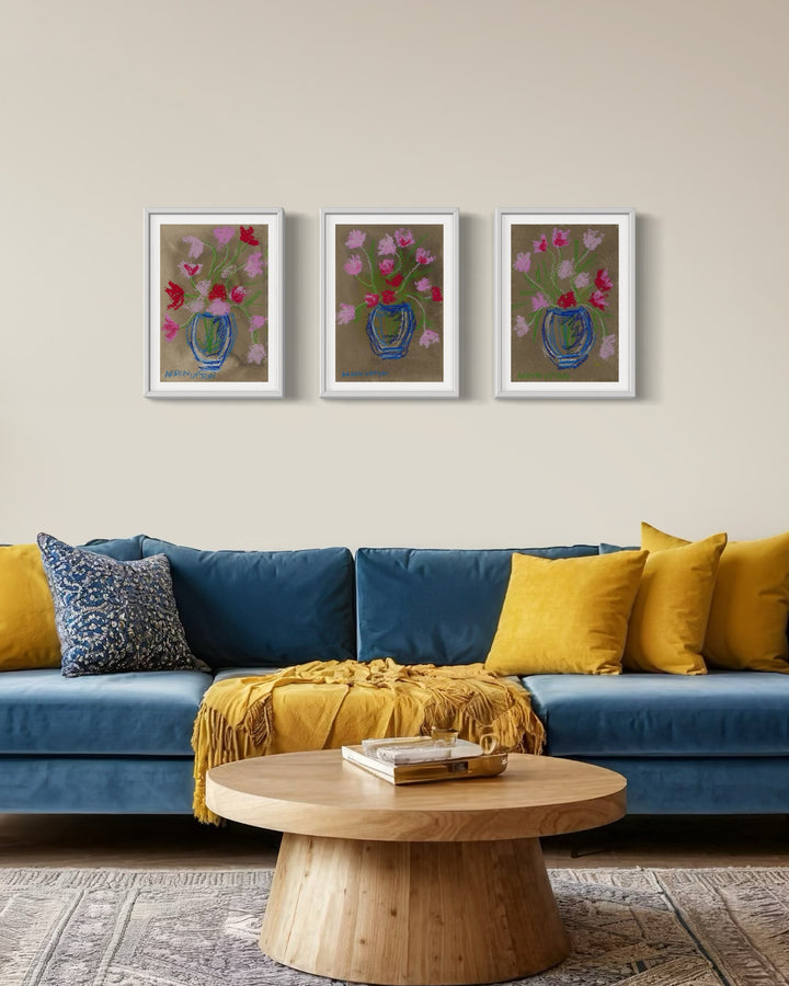 A gallery wall of 3 framed fine art giclée prints of a mixed media painting featuring pink and red flowers in blue vases on a beige background. Part of Arden Upton's Flowers that Last collection 