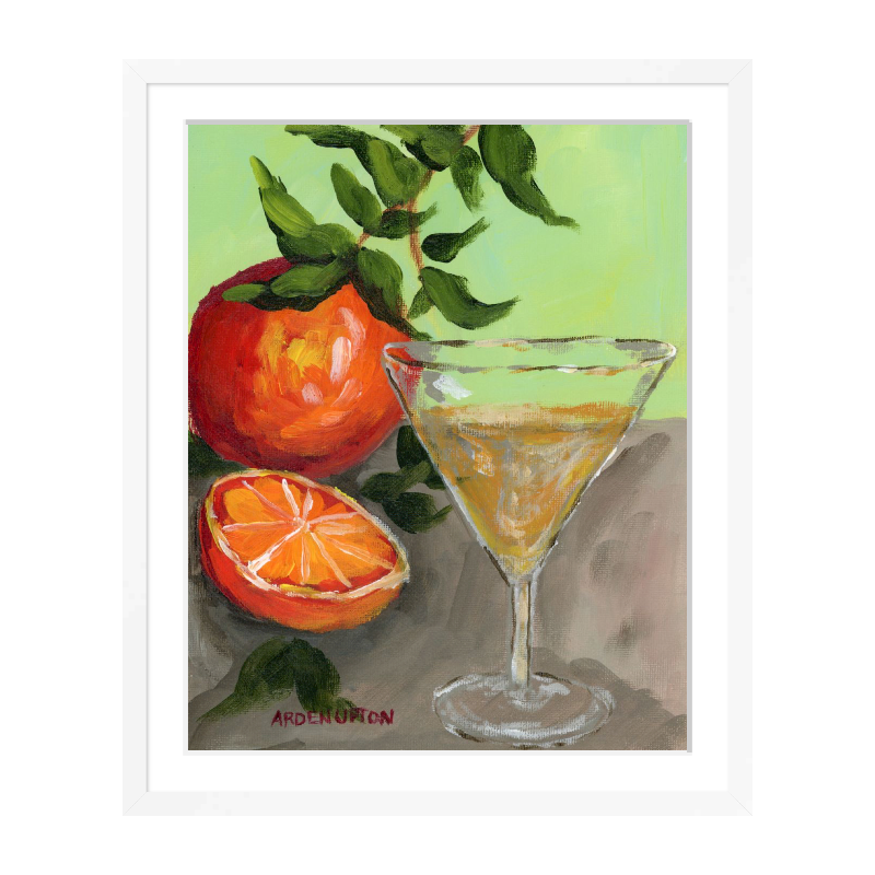 A painting of a yellow Martini and an orange and a half on an orange tree stem sitting. on grey table painted in bold orange, red and green colors, with great texture and detail framed in a white frame. great for for kitchens, pantries, dining rooms, and entertaining spaces