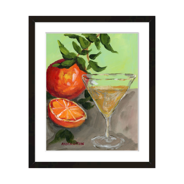 A painting of a yellow Martini and an orange and a half on an orange tree stem sitting. on grey table painted in bold orange, red and green colors, with great texture and detail framed in a black frame. great for for kitchens, pantries, dining rooms, and entertaining spaces