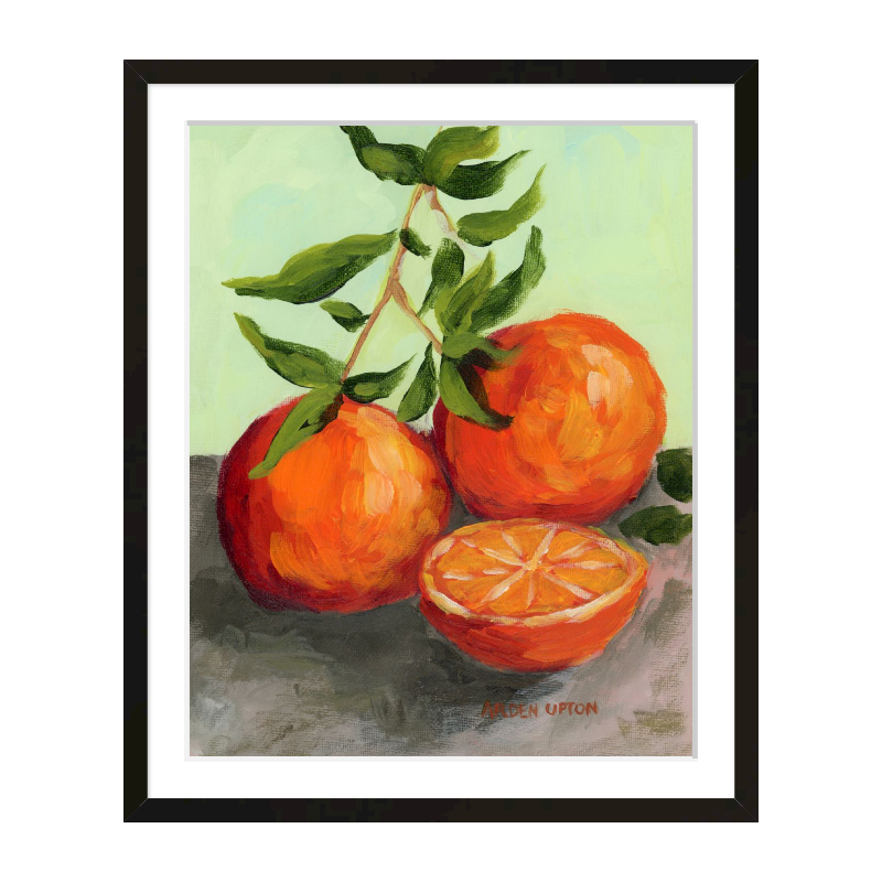 Kitchen gallery wall décor – foodie paintings with life-like oranges in orange, red, and lime green, framed in black or white.