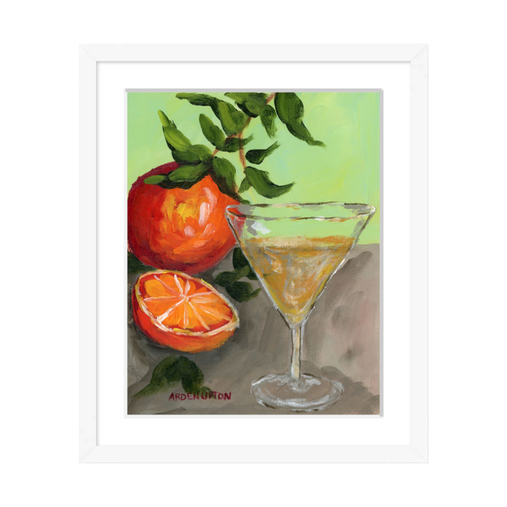 A painting of a yellow Martini and an orange and a half on an orange tree stem sitting. on grey table painted in bold orange, red and green colors, with great texture and detail framed in a white frame. great for for kitchens, pantries, dining rooms, and entertaining spaces