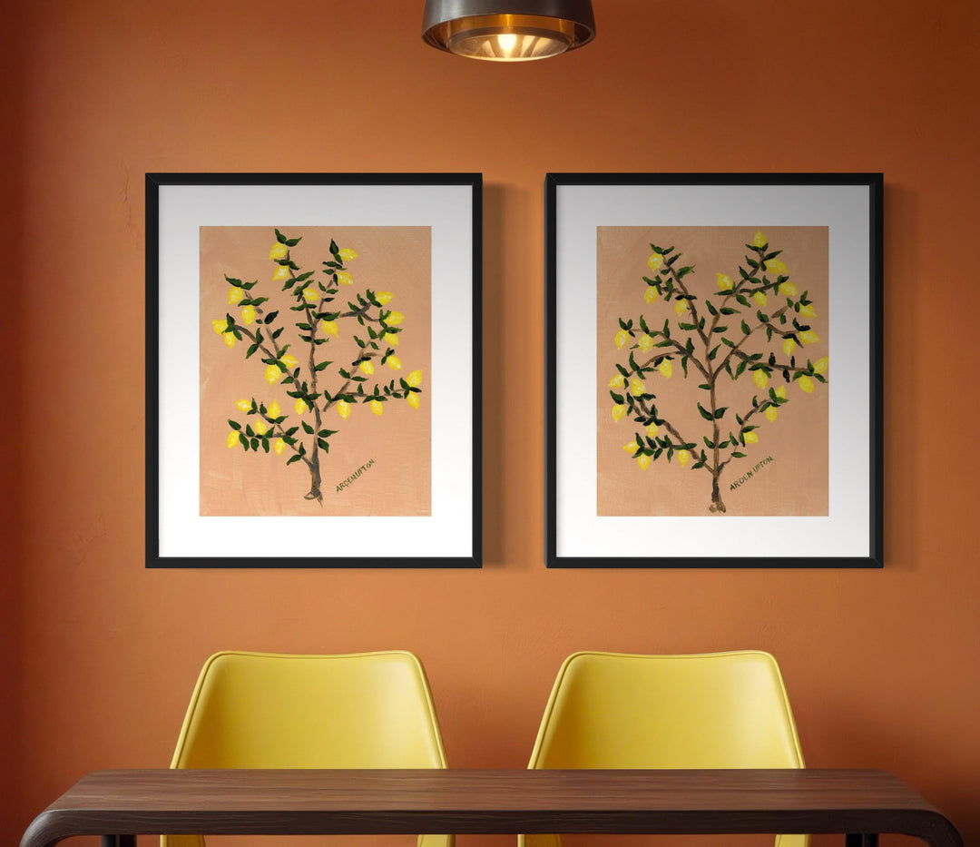 Gallery wall of 2 large lemon tree prints of painting from Arden Upton's Lemonade Series with bright yellow lemons and green leaves on a lemon tree styled over a desk 