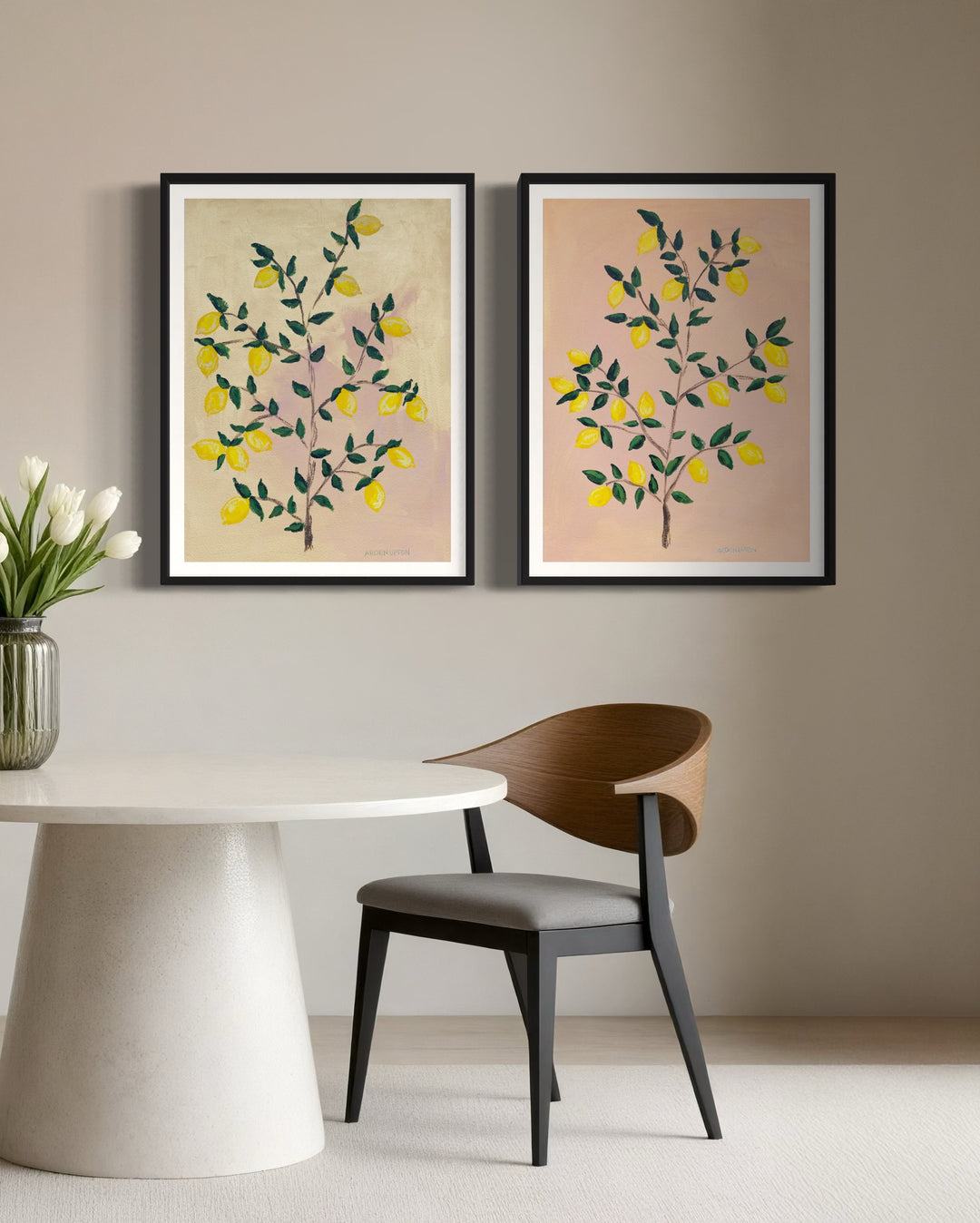 2 museum-quality fine art giclée prints of a lemon tree, featuring vibrant yellow lemons on a lemon tree with green leaves against a pink and yellow background, part of Arden Upton's Lemonade Series and styled side by side over a table