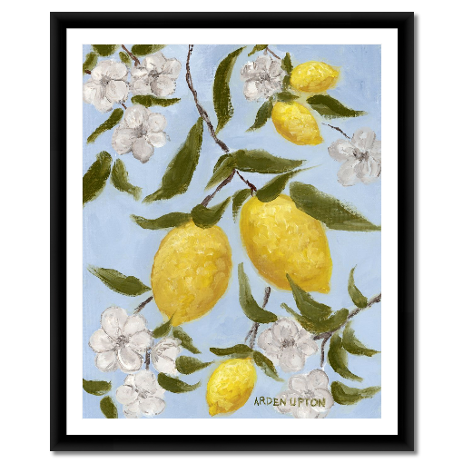 A framed art print featuring a painting from Arden Upton's Lemonade Collection of lemons , leaves and white floral elements against a blue background, with a white mat and black frame.