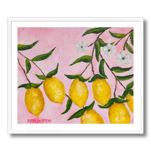 A framed art print featuring a painting from Arden Upton's Lemonade Collection of lemons, leaves and white floral elements against a pink background