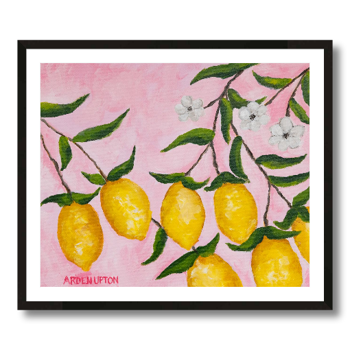A framed art print featuring a painting from Arden Upton's Lemonade Collection of lemons, leaves and white floral elements against a pink background