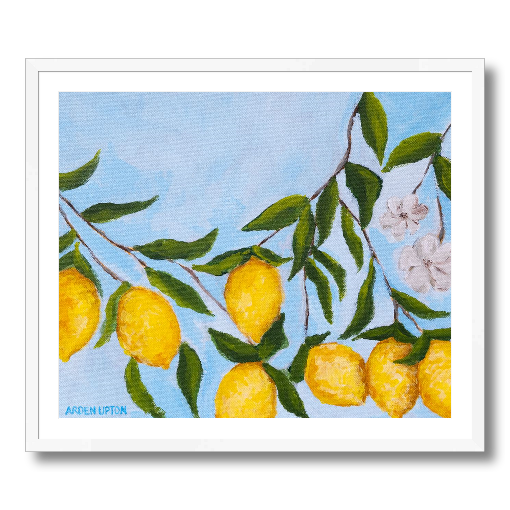A framed art print featuring a painting from Arden Upton's Lemonade Collection of lemons , leaves and white floral elements against a blue background, with a white mat and black frame.