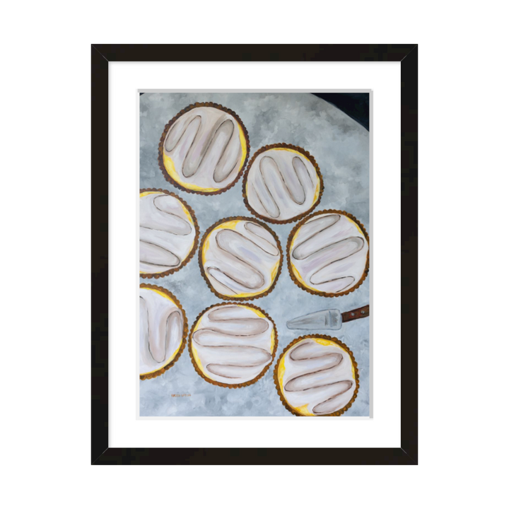 A painting by Southern artist Arden Upton of eight beautifully baked lemon tarts on a table with a tart server. Framed in a black frame