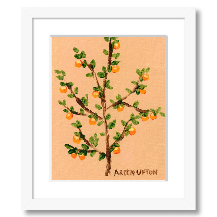 A framed artwork of an orange tree with green leaves and orange fruits on a peach-colored background, signed by Arden Upton.