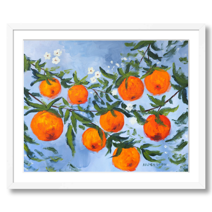 A ready to hang, framed giclee art print featuring a painting of oranges on a tree with white flowers and a blue sky background by Arden Upton from her Orangerie Collection. Art for Gallery walls, kitchens, bright and happy spaces