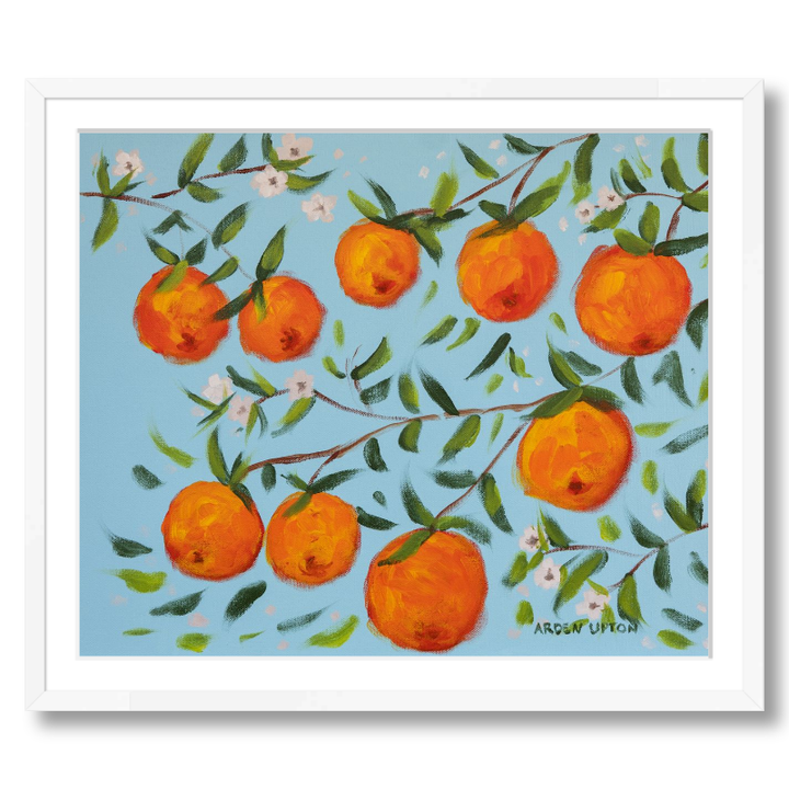 A ready to hang, framed giclee art print featuring a painting of oranges on a tree with white flowers and a blue sky background by Arden Upton from her Orangerie Collection. Art for Gallery walls, kitchens, bright and happy spaces