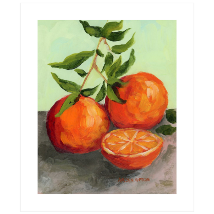 Easy hang dining room art collection – foodie gallery wall citrus paintings in black and white frames for stylish dining or kitchen décor. Painting shows two and a half beautifully detailed oranges with a stem of greenery